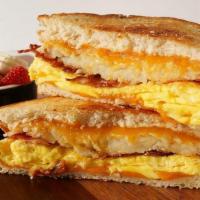 Breakfast Sandwich · Freshly baked grilled sourdough bread, bacon or sausage, golden hashbrowns, scrambled eggs, ...