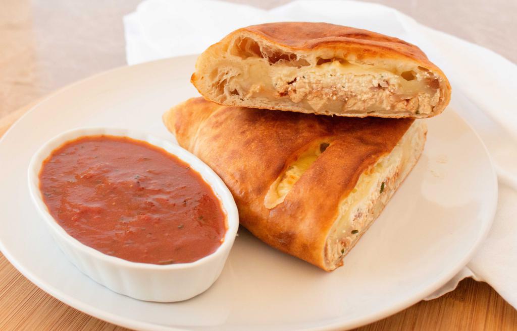 Bbq Veggie Chicken Calzone · Pizza dough folded and stuffed with ricotta cheese, mozzarella cheese, BBQ veggie chicken, & red onion. Oven baked. Served with marinara sauce.