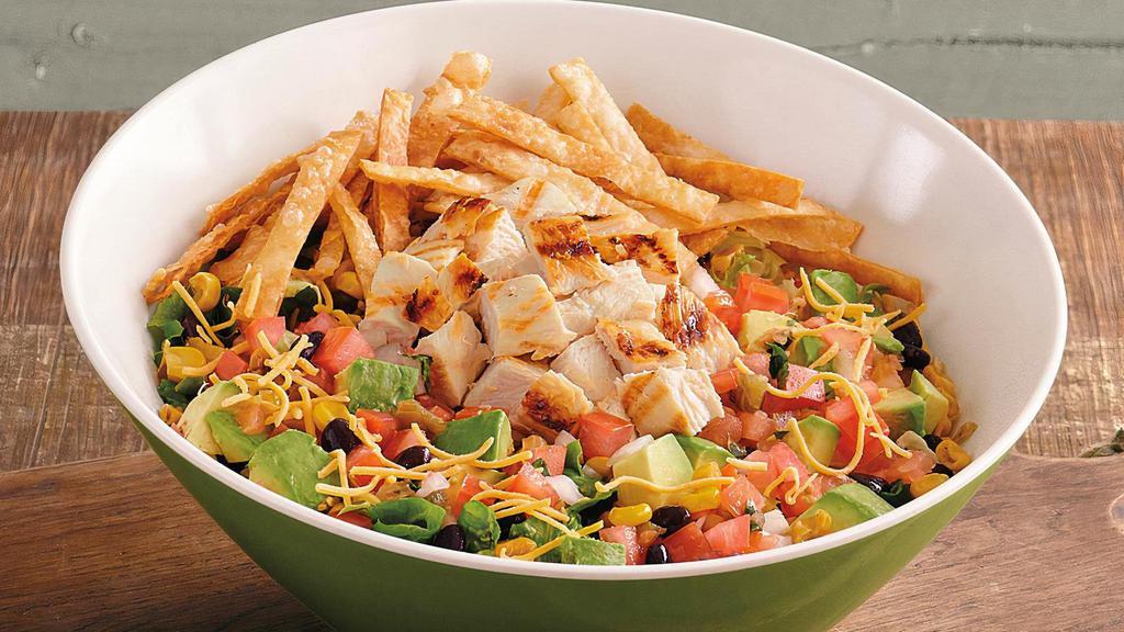 Southwest Chicken Salad · Loaded with grilled all-natural chicken breast, fire-roasted corn, black beans, shredded cheddar cheese, hand-diced Hass avocado, house-made salsa, crunchy tortilla strips, and served with house-made spicy-cool chili ranch dressing on farm fresh greens. Savor the flavor!