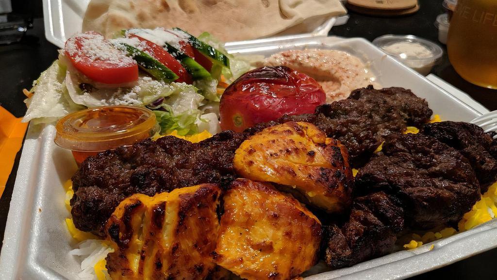 Combo Plate · Three pieces of beef and chicken and one skewer of luleh with rice, a green salad, hummus, grilled tomato, pita bread and garlic and beef sauces.