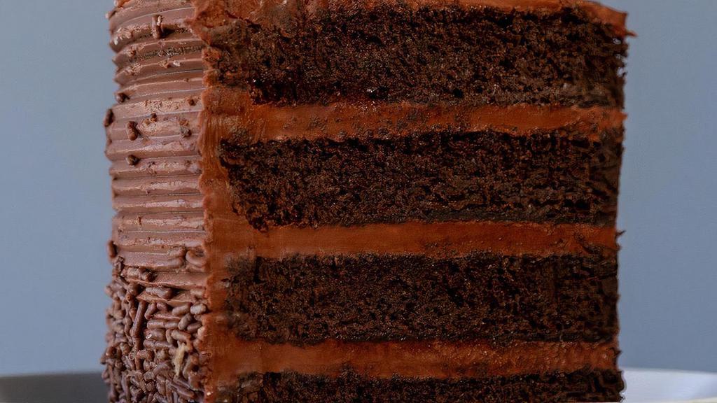 Chocolate Fudge Cake Slice · Layers of decadent chocolate cake filled and iced with chocolate fudge frosting and topped with chocolate sprinkles.