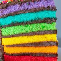 Rainbow Fudge Cake Slice · Six layers of rainbow-colored vanilla cake filled and iced with rich chocolate fudge icing, ...
