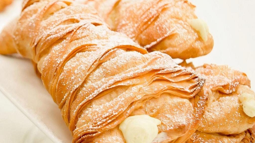 Traditional Lobster Tail · Hand-pulled flaky dough baked to a golden brown, filled with our signature French cream and a hint of Bailey's liqueur, topped with powdered sugar.