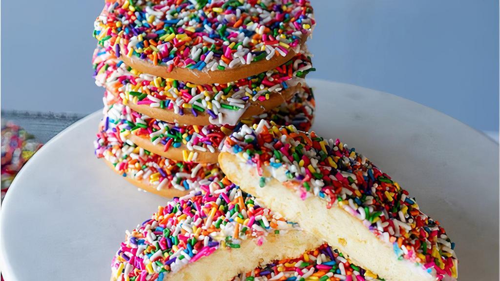 Vanilla Rainbow Cookie · Soft cake-like cookie covered in vanilla icing and rainbow sprinkles.