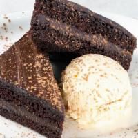 Seasonal Chocolate Cake · Rich chocolate cake topped with chocolate icing. Served with vanilla ice cream.