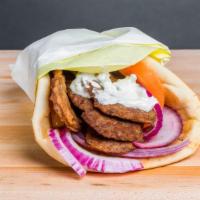 Gyro · Gyro meat with tzatziki, red onion and tomato all wrapped up in a fresh pita.