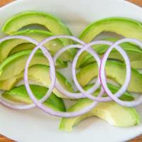 Ensalada De Aguacate (Avocado Salad) · Sliced has avocado topped with onions.