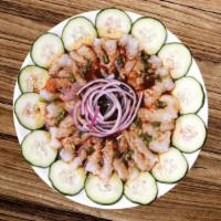 Aguachile · Shrimp cured in lime juice, cucumber slices, red onion and black sauce.