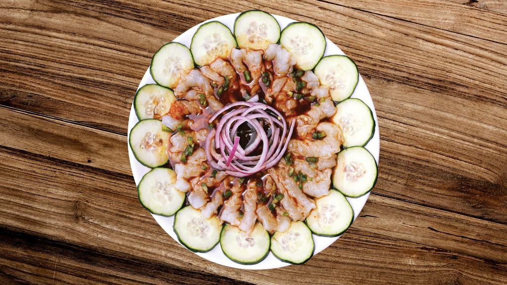Aguachile · Shrimp cured in lime juice, cucumber slices, red onion and black sauce.