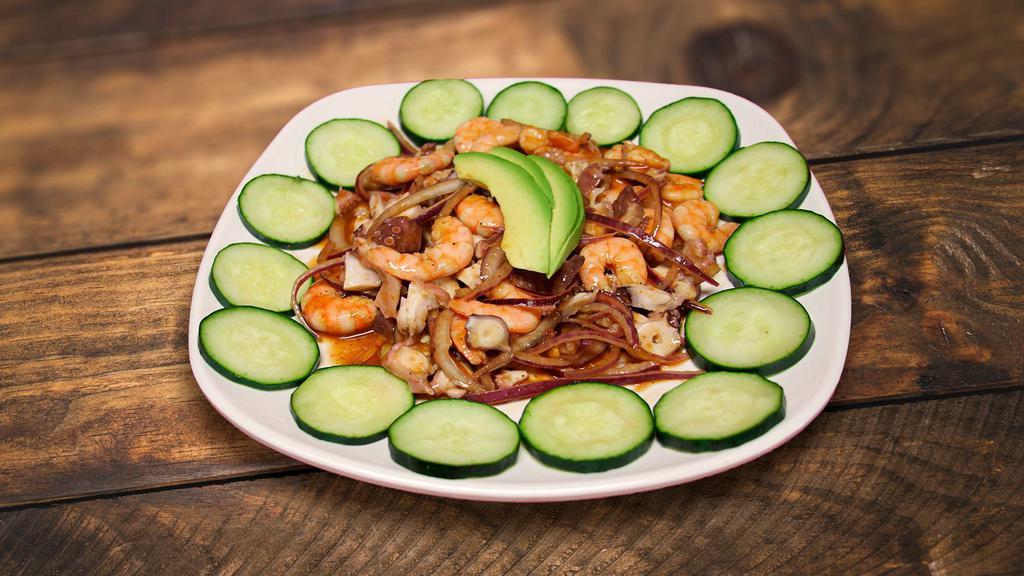 Shrimp & Octopus · Cooked shrimp, octopus, sliced cucumber red onion, avocado tossed, and our delicious salsa negra.