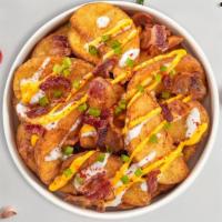 Loaded Potato Wedges · Baked potatoes topped with bacon, cheddar, smoked paprika, sour cream and scallions.