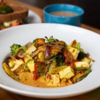 Indian Curry With Tofu · Cooked veggies in a curry sauce, served with a side of rice and salad.