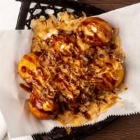 Takoyaki · Octopus takoyaki balls with special takoyaki sauce and sweet bonito flakes on cast iron plate.