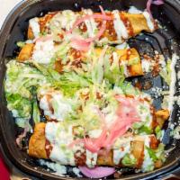 Flautas De Maiz · Four corn flautas filled with your choice of carnitas, chicken or beef. Topped with fresh gu...