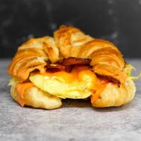 Croissant Bacon, Egg And Cheddar Sandwich · 2 scrambled eggs, melted Cheddar cheese, smoked bacon, and Sriracha aioli on a  warm croissant