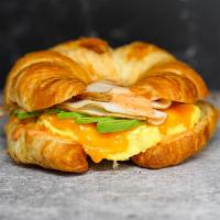 Croissant Smoked Turkey, Egg, And Avocado Sandwich · 2 scrambled eggs, melted Cheddar cheese, smoked turkey, avocado, and Sriracha aioli  on a wa...