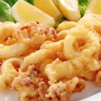 Fried Calamari · deep fried squid drizzled with house made lemon cream sauce all on top of lemon wedge.