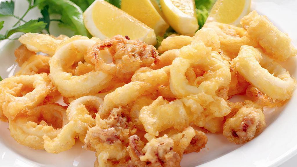 Fried Calamari · deep fried squid drizzled with house made lemon cream sauce all on top of lemon wedge.