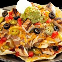 Ultimate Nachos · Vegan. Tortilla chips smothered with cheese, refried beans and enchilada sauce, jalapeños, t...