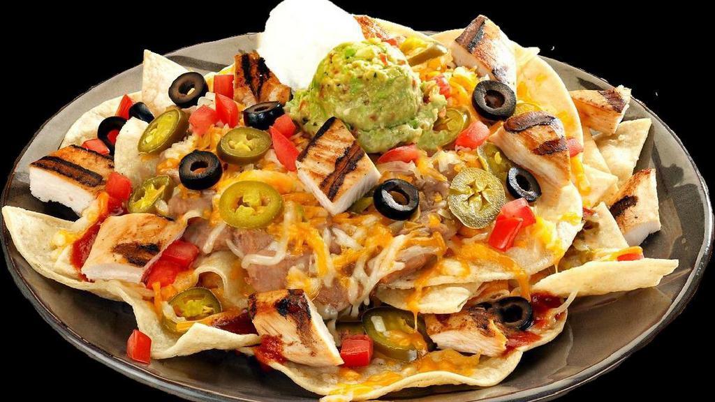 Ultimate Nachos · Vegan. Tortilla chips smothered with cheese, refried beans and enchilada sauce, jalapeños, tomatoes, black olives, sour cream, and guacamole.