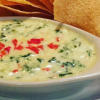 Espinaca Con Queso · A creamy cheese dip spiced with jalapeños, spinach, onions and peppers.