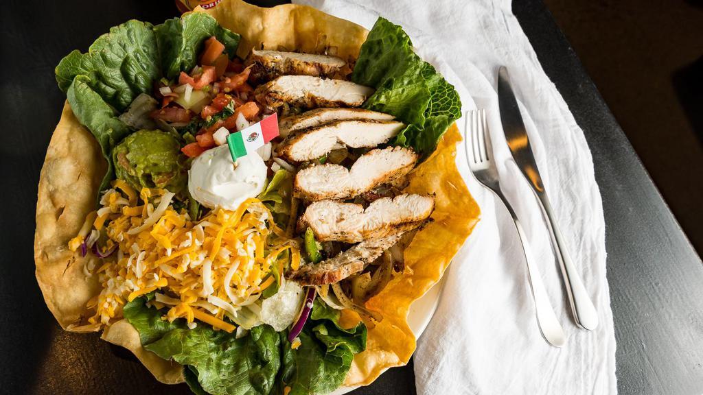 Fajita Salad · Grilled marinated sirloin or chicken breast with grilled peppers and onions on crisp salad greens in a tortilla shell with pico de gallo, sour cream, cheese and guacamole.