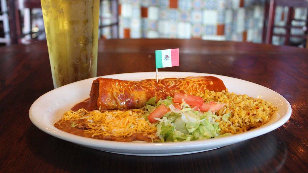 Grande Burrito · A giant flour tortilla stuffed with choice of chicken, shredded beef, chili verde, red chile or ground beef and smothered with sauce. Served with Spanish rice and choice of refried, charro or black beans.