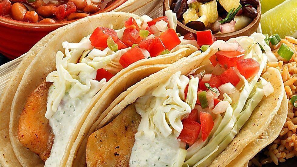 Grilled Fish Tacos · Two corn tortillas with grilled tilapia, tomatillo mayonnaise, shredded cabbage, pico de gallo, and cilantro. Served with a side of salsa de pina, Spanish rice and choice of beans.