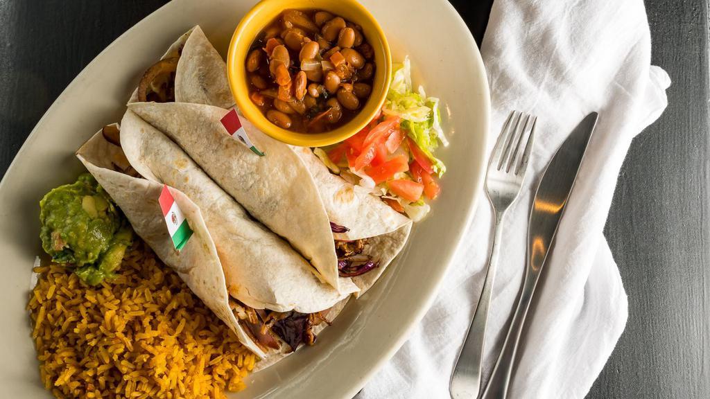 Carnitas (Pork) Tacos · Slow-cooked sauteed pork, red cabbage, grilled red onions, pico de gallo, and guacamole. Served with Spanish rice and choice of beans.