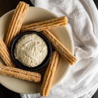Churros · Fluffy pastry sticks rolled in cinnamon and sugar, served with sweet cream cheese.
