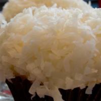 Double Coconut Cupcake · Coconut cake with cream cheese frosting and a flakey coconut topping.