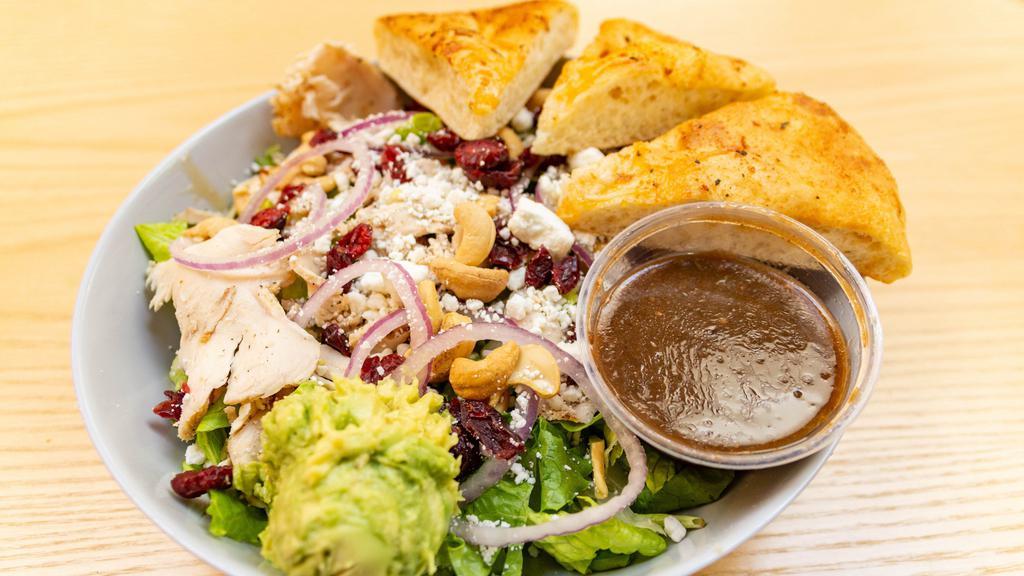 Goat Cheese Chicken Salad · Mixed greens, grilled chicken breast, goat cheese, bacon, red onions, avocados, roasted cashews, dried cranberries, and honey balsamic dressing. Salads include oven fresh focaccia bread.