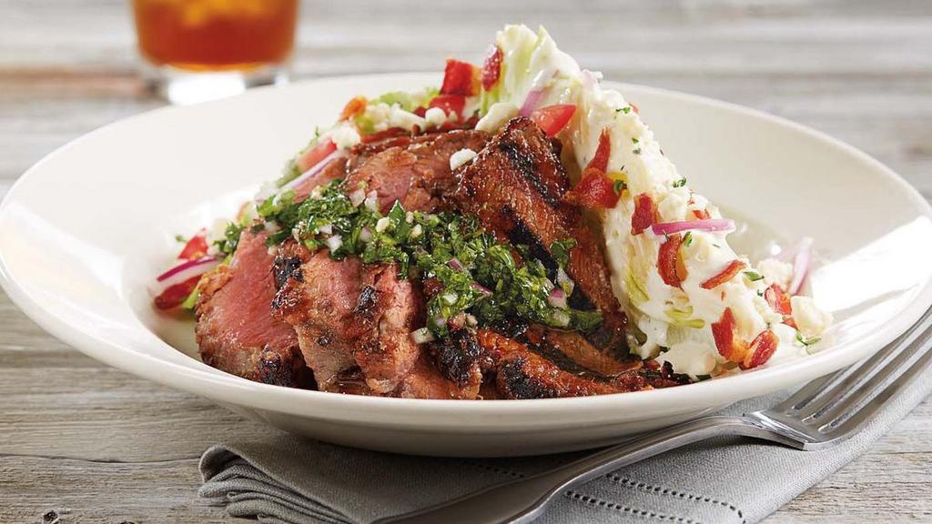 Tri-Tip Wedge* · We start with a crisp wedge of iceberg lettuce and top it with a slow-roasted, BBQ glazed, sliced sirloin tri-tip, applewood smoked bacon, bleu cheese crumbles, red onions, and fresh tomatoes.  Served with a side of bleu cheese dressing and chimichurri sauce.