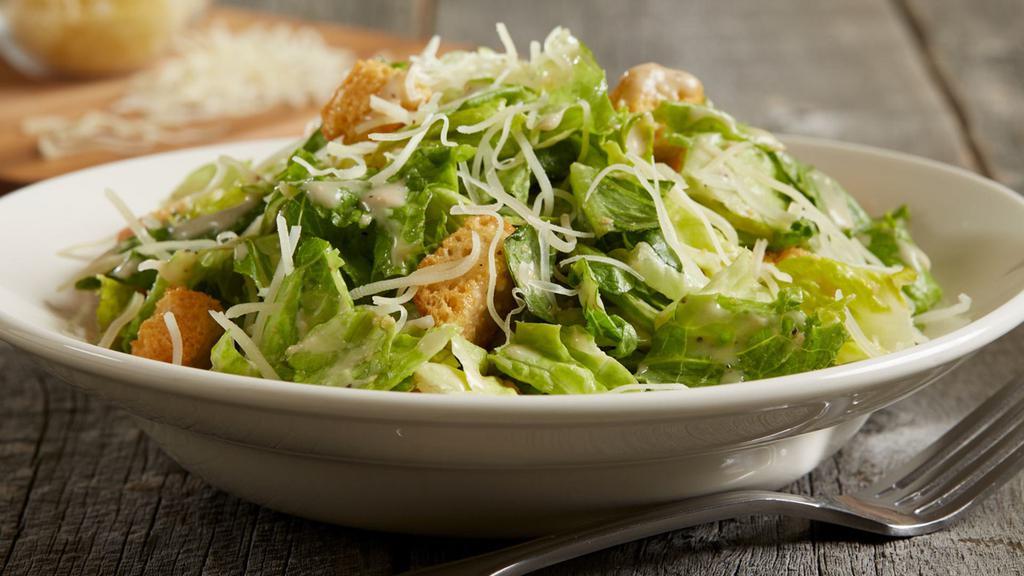Caesar Salad · Crisp romaine lettuce tossed with seasoned, oven-baked croutons, shredded parmesan cheese and served with a side of creamy caesar dressing.