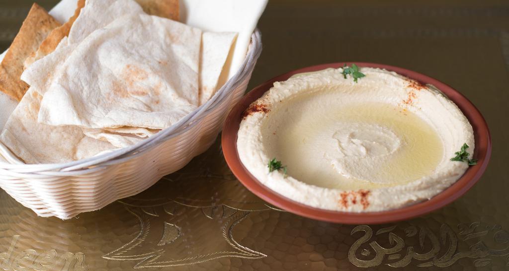 Hummus · Gluten-free. A delicious Middle Eastern blend of garbanzo beans tahini, fresh garlic, lemon & olive oil. Vegan.