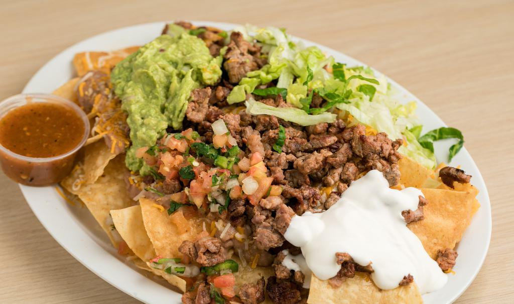 Nachos · Nachos include: 

Your Choice of Carne Asada or Grilled Chicken;
Chips,
Beans,
Shredded Cheddar and Monterey Jack Cheese,
Shredded Lettuce,
Pico de Gallo,
Fresh Guacamole,
Sour Cream.

Homemade Red Salsa on the side.