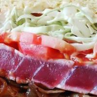 Seared Ahi Tuna Burger · Raw. Sushi grade ahi tuna seared and served with caramelized onions, cabbage, tomatoes and w...