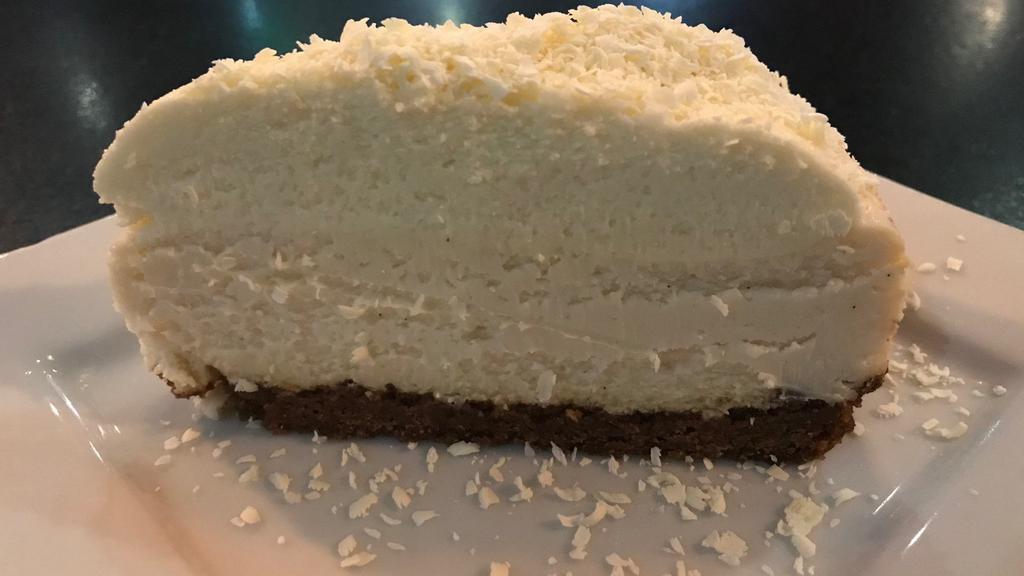 Vanilla Bean Cheesecake · Homemade vanilla bean cheesecake on graham crust topped with white chocolate mousse and shaved white chocolate.  It's not New York, it's awesome.