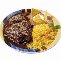 Mole Poblano · Authentic Mexican Mole sauce served with chicken accompanied with red rice, refried beans an...