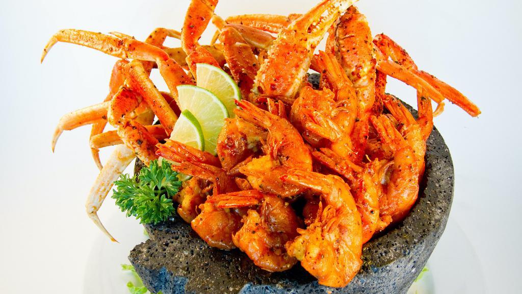 Molcajete De Mariscos · Sauteed peel on Shrimp, Crab Legs and whole fried mojarra fish in our spicy citrus sauce served over a bed of romaine Lettuce, Garnished with fresh cilantro, served with two sides of rice, refried beans,  Pico de Gallo, Guacamole and your choice of Tortillas.