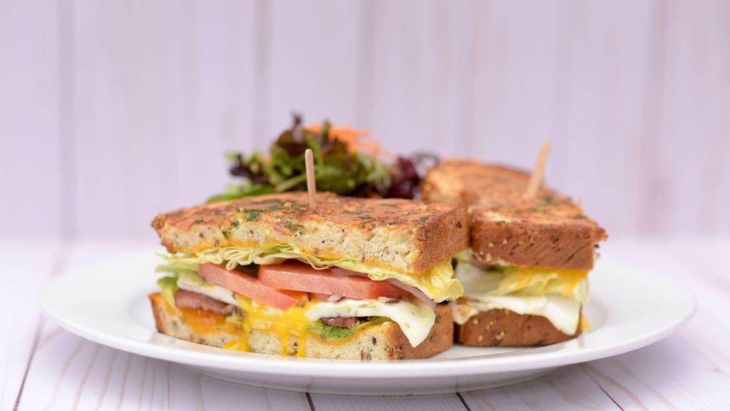 Grilled Breakfast Sandwich · Over Medium eggs, uncured bacon, avocado, red onion, tomato, lettuce, mayo, cheddar cheese on sourdough or multigrain. with breakfast side.