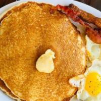 Pancake Breakfast · Two extra large fluffy pancakes. Served with two eggs and your choice of bacon, ham or sausa...