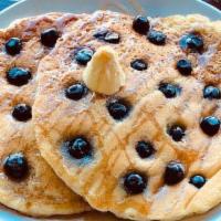 Big Short Stack With Blueberries · Two large fluffy blueberry pancakes served with maple syrup.