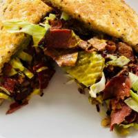 Hot Pastrami Sandwich · Grilled French roll topped with pastrami, pickles, mayonnaise, mustard, onions, lettuce, and...
