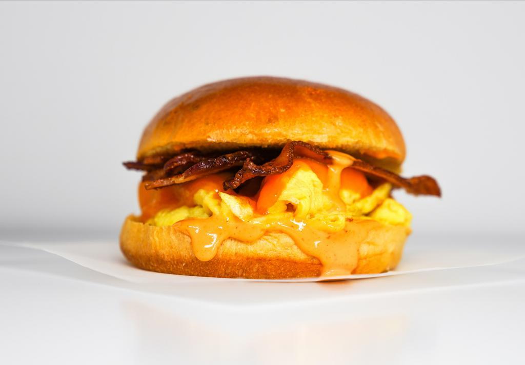 Brioche, Bacon, Egg, & Cheddar Sandwich · 2 scrambled eggs, melted Cheddar cheese, smoked bacon, and Sriracha aioli on a warm brioche bun.