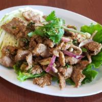 Nam Tok  · Grilled beef or pork with mint leaves, red onion, rice powder, chili and lime juice.