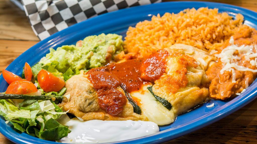 Chile Relleno · One pasilla chile, egg battered, with cheese inside. Includes rice, beans, sour cream, guacamole, lettuce, tomatoes and tortillas.