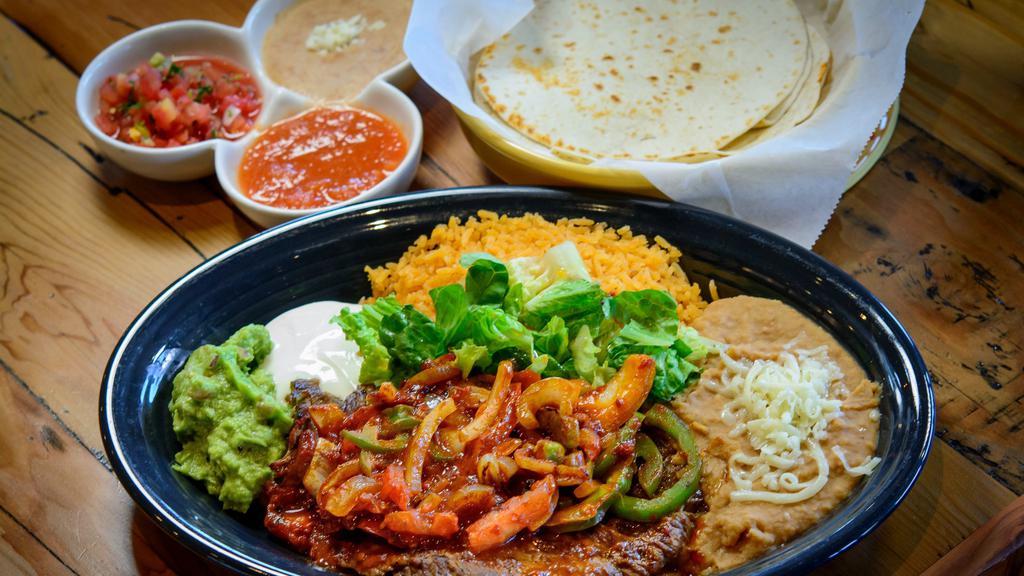 Steak A La Mexicana · Marinated steak grilled with bell pepper, onions and tomatoes. Includes rice, beans, sour cream, guacamole, lettuce, tomatoes and tortillas.