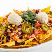 Nachos [Gf] · corn tortilla chips, black beans, cashew cheese, chipotle sauce, salsa fresca, roasted corn,...