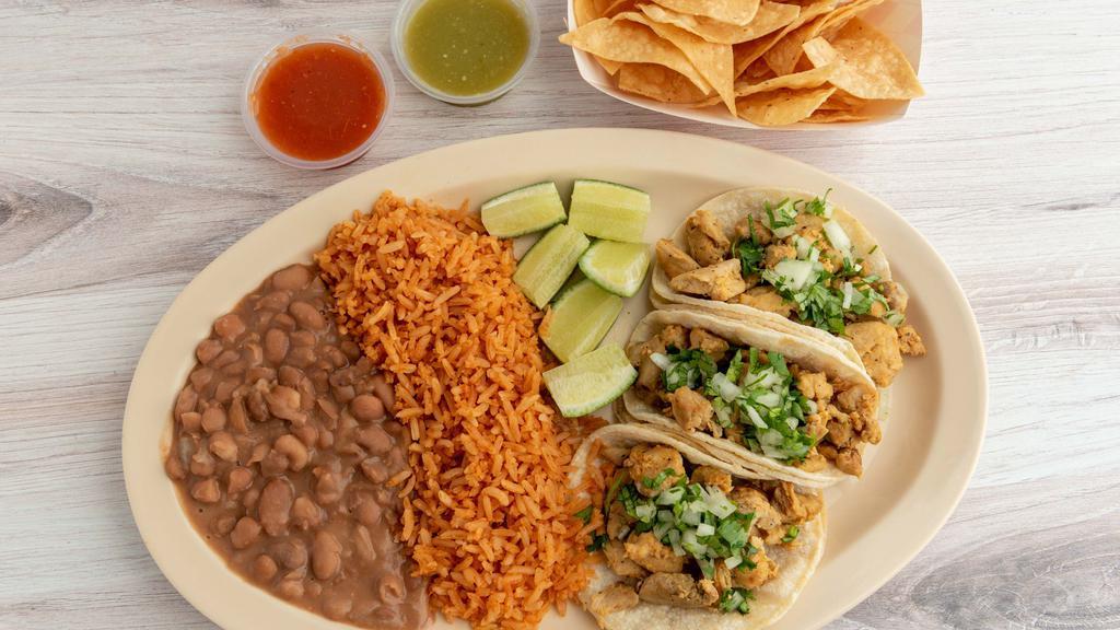 Tacos Box · 3 corn tortillas tacos with your choice of meat, (steak, chicken, carnitas, al pastor) toppings: limes, cilantro, and onions served with rice, beans, chips, salsa and guacamole.
